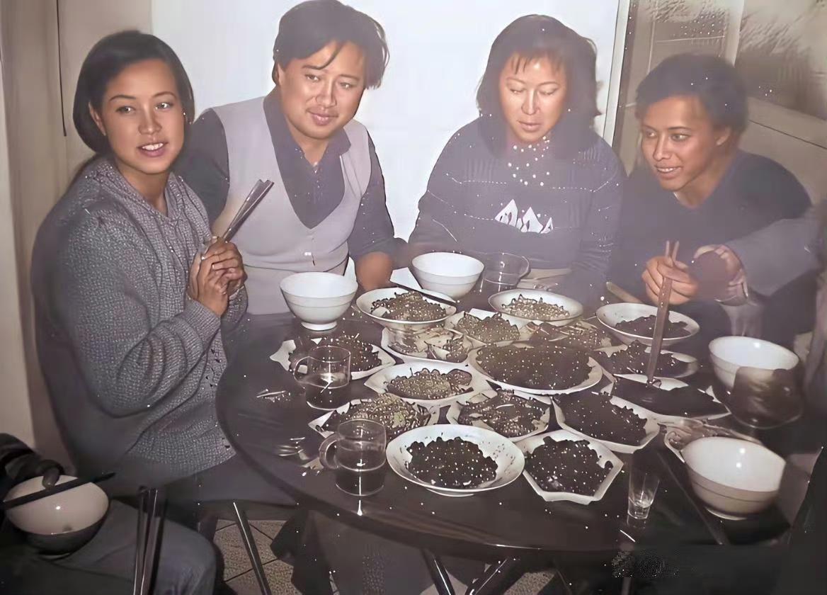 当年春节，刘晓庆带着恋人陈国军回四川老家过年，和家人一块儿吃年夜饭的照片。​