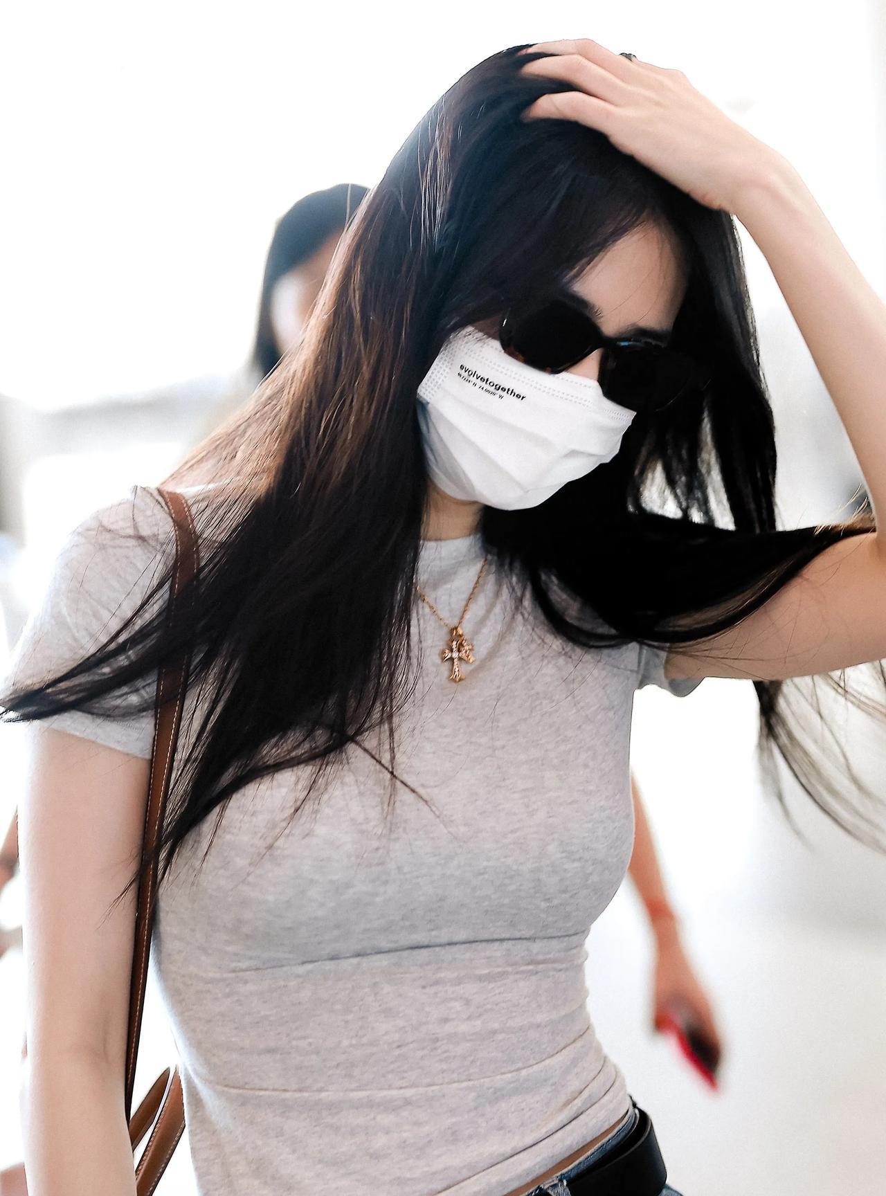 徐璐机场路透，灰色紧身上衣搭牛仔裤，勾勒出性感曲线。墨镜遮面难掩精致，发丝轻扬间