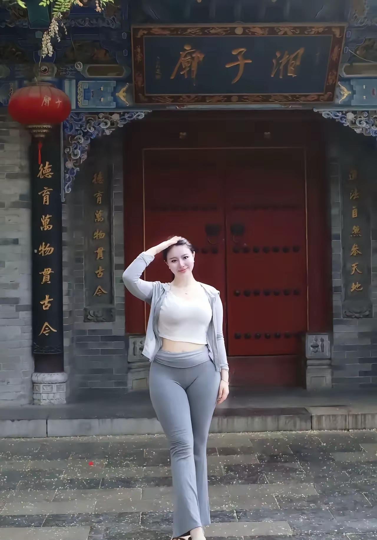 庙前留影古庙宇前身影立，红门灰壁岁月遗。微风轻拂衣袂起，一笑留存时光里。