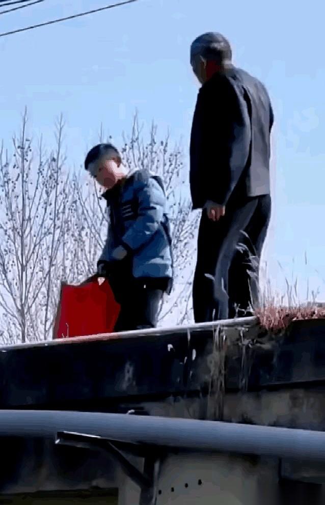 老人一只脚已经跨上了大桥栏杆。就在几秒钟前，他不过是抬手，轻轻拍了一下那孩子的