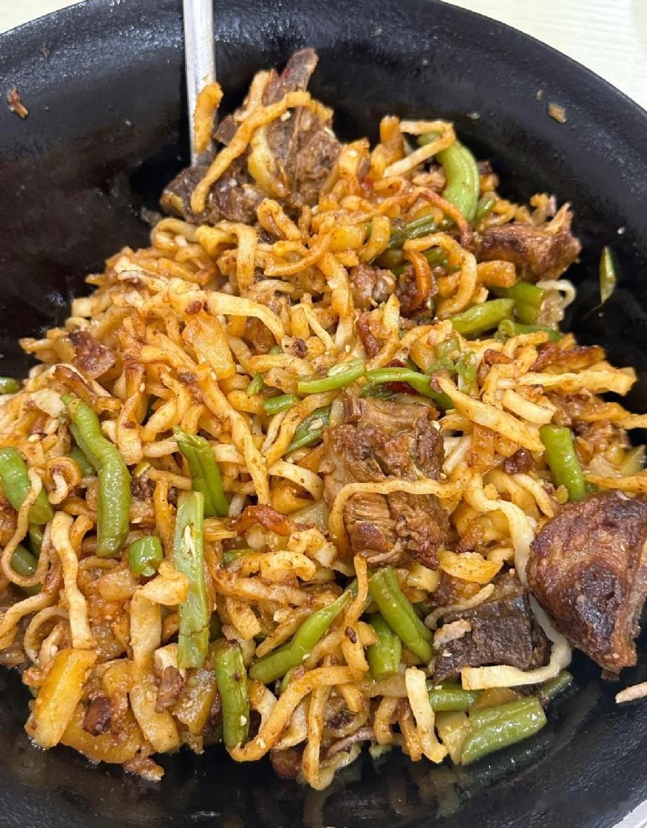 中午在饭店点了一锅排骨焖面，端上桌瞬间就香到了。黑铁锅满满一大份，炖得软烂的排骨