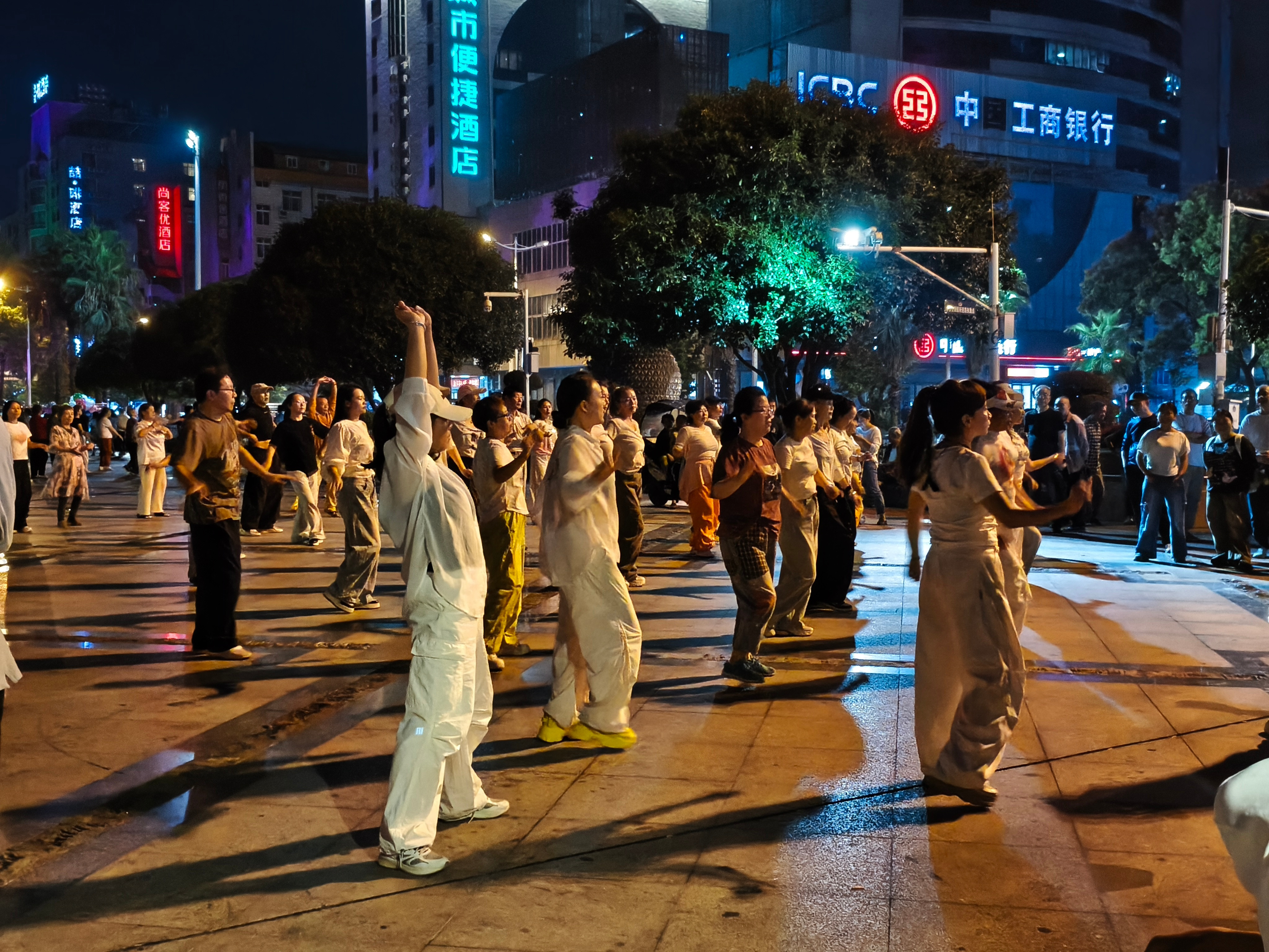 一群大妈跳广场舞，一群大爷围着欣赏​​​