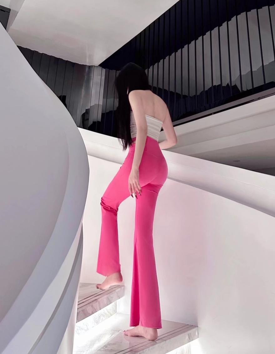 粉裤少女，轻盈漫步在现代楼梯间