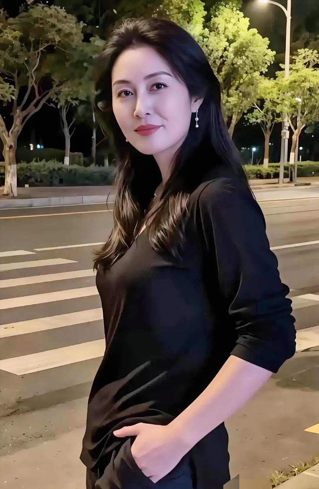 《夜街静影》黑衣轻裹夜色的柔，长发半垂肩头的幽。单手轻插口袋的随性，
