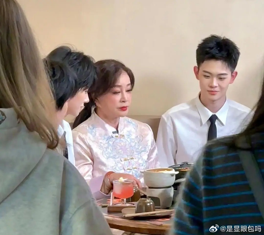 刘晓庆在重庆一家餐馆吃烤鱼，她身边有一位打着领结的帅气小鲜肉在陪着她，一边吃一边