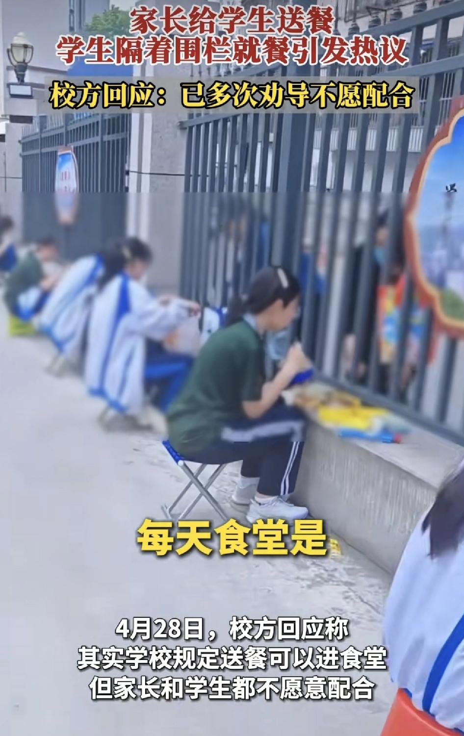 湖北实验一中学门口有学生家长午饭时间送饭到学校门口，学生隔着围栏吃饭，引发了网友