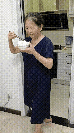 这是一个好婆婆，她把饭做好全部端在桌子上，儿媳妇和孙子开心地吃着饭，等她端着一碗