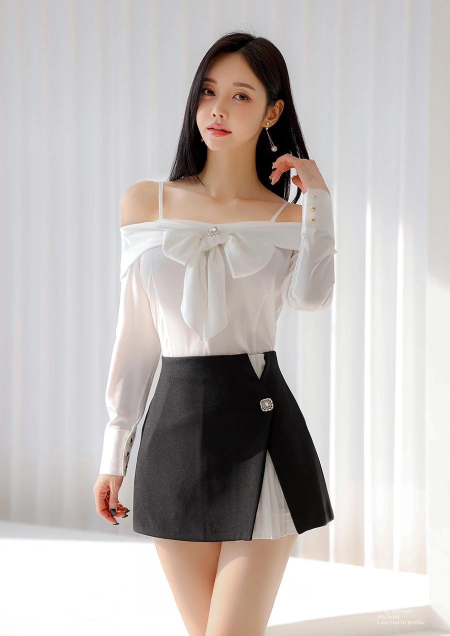 孙允珠身着白衬衫搭配黑色短裙的造型，堪称简约时尚的典范！白衬衫搭配黑领带，尽显利