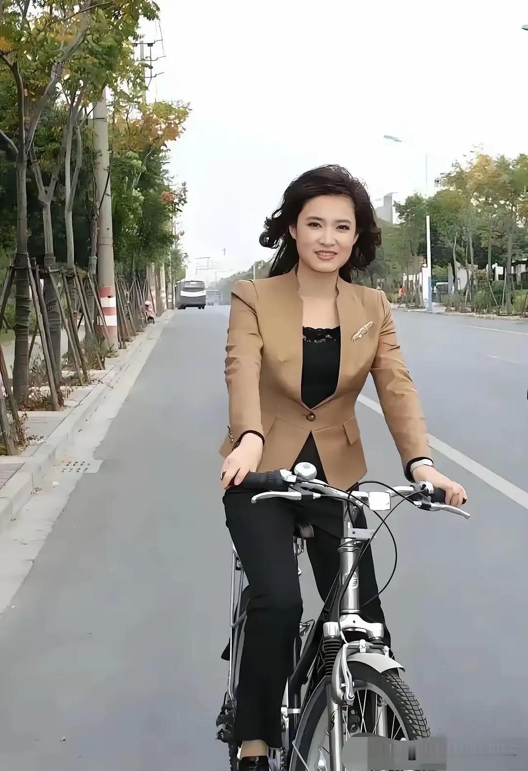 桑晨下班之后骑着自行车，53岁的她身材苗条、皮肤紧致，一头齐肩的微卷短发特别年轻