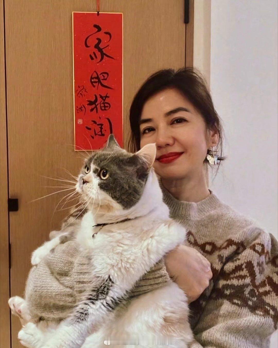 65岁钟楚红和宠物猫合照，她化着大红唇，脸蛋圆润，看起来气血充盈，美得很大气，状