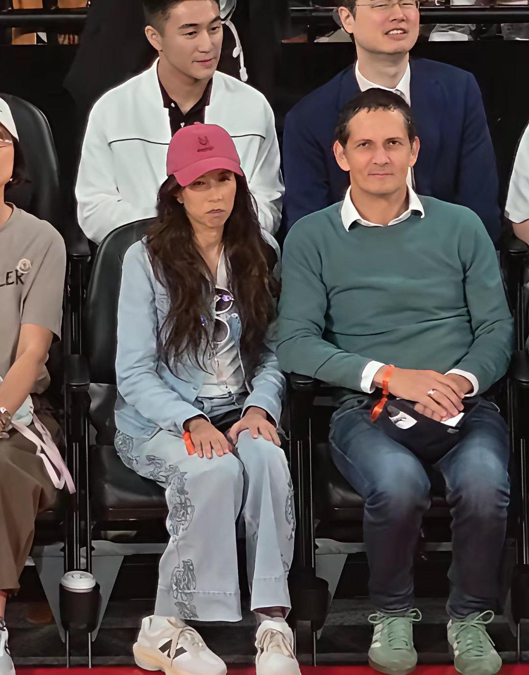 55岁莫文蔚和德国籍老公一起在澳门看篮球比赛，夫妻俩坐在第一排，看起来很恩爱，她