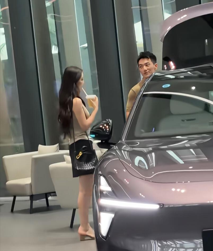 39岁张馨予和老公何捷现身广州一间车企看豪车，她背着4万元的名牌包，打扮时尚贵气
