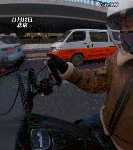 看哭了，北京，一女子骑着摩托车在等红绿灯时播放音乐，骑车路过的一名小伙觉得女子摩