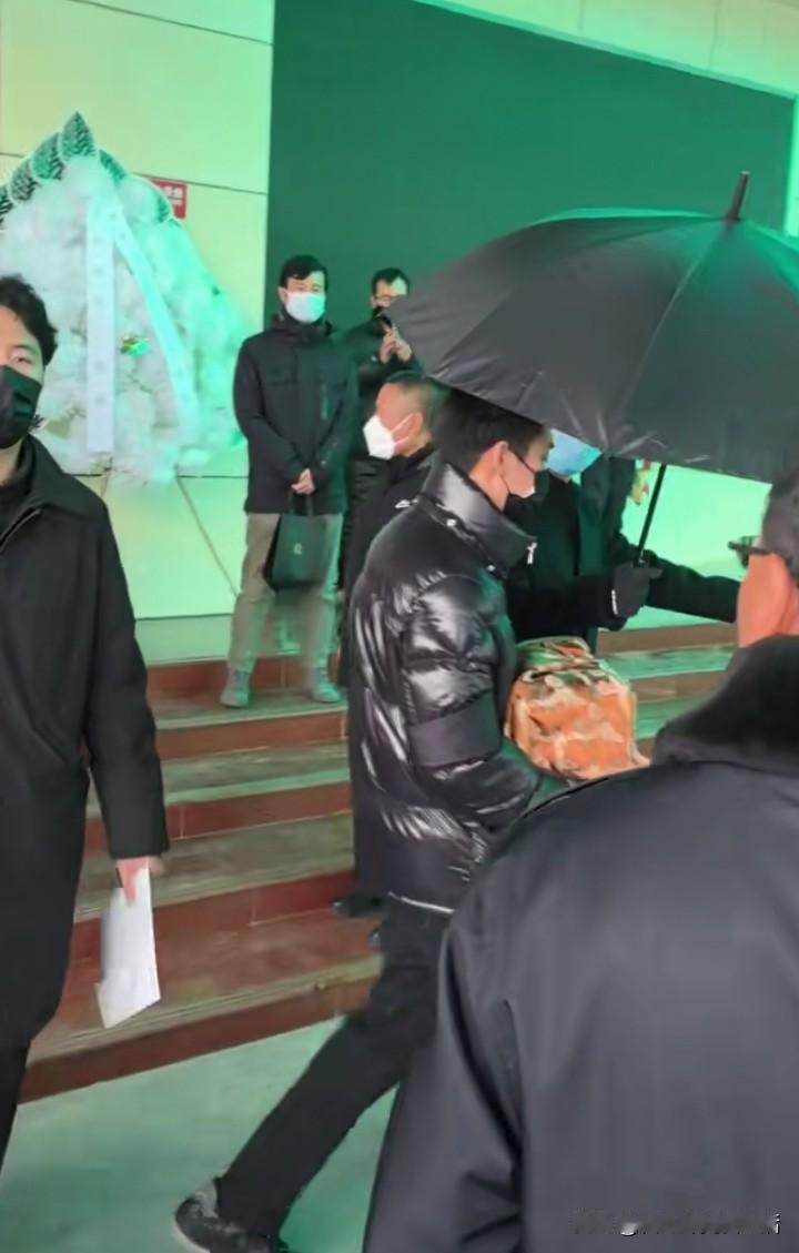 何晴的儿子许何捧着妈妈的骨灰，从里面走出来。许亚军也陪着儿子，参加了前妻的追悼