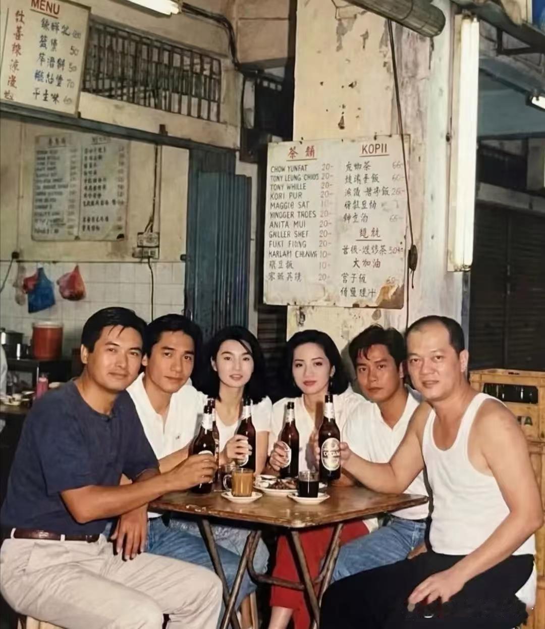 一张在香港小饭馆拍的合照，周润发、梁朝伟、张曼玉、梅艳芳、谭咏麟都在，几个人手里攥着啤酒，状态特别放