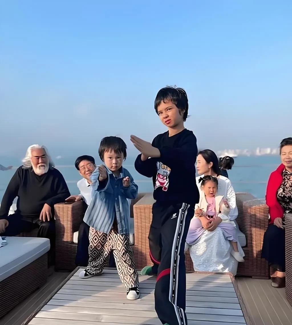 这是张纪中一家人在外游玩的照片，前面耍功夫的是大儿子马丁，帅气有型，很有功夫巨星