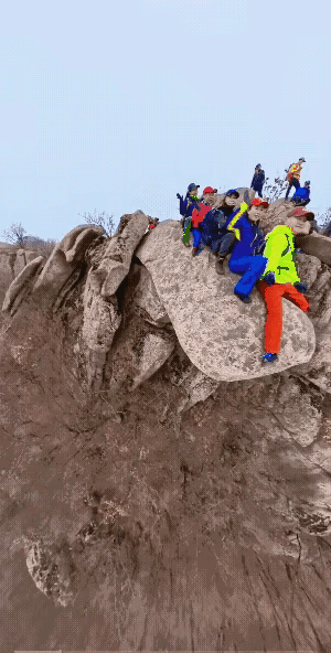 看着心里都慌，这个男人怎么这么不惜命呢？他一个人坐在了这个石头的最前面，后面还有