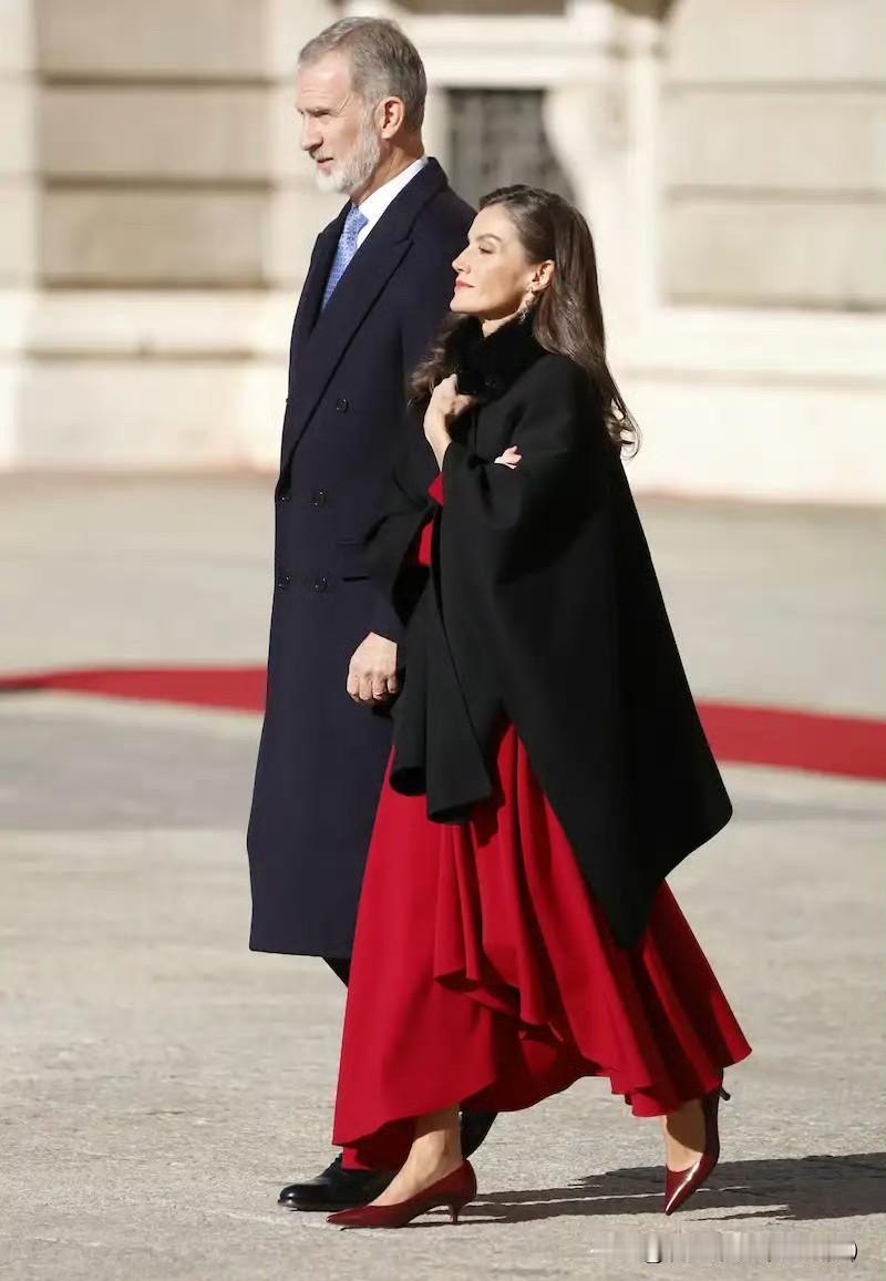 王后是真不怕冷啊！欢迎仪式上，聊着聊着就脱掉了黑色斗篷，不规则裙摆时尚个性，酒红