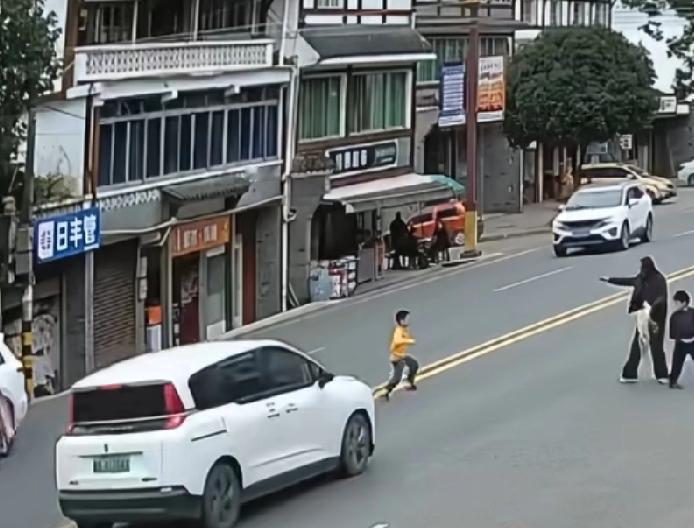 小孩飞奔过马路被车撞倒拖行数米，家属情绪激动晕倒，众人抬车救人双黄线横穿马路，