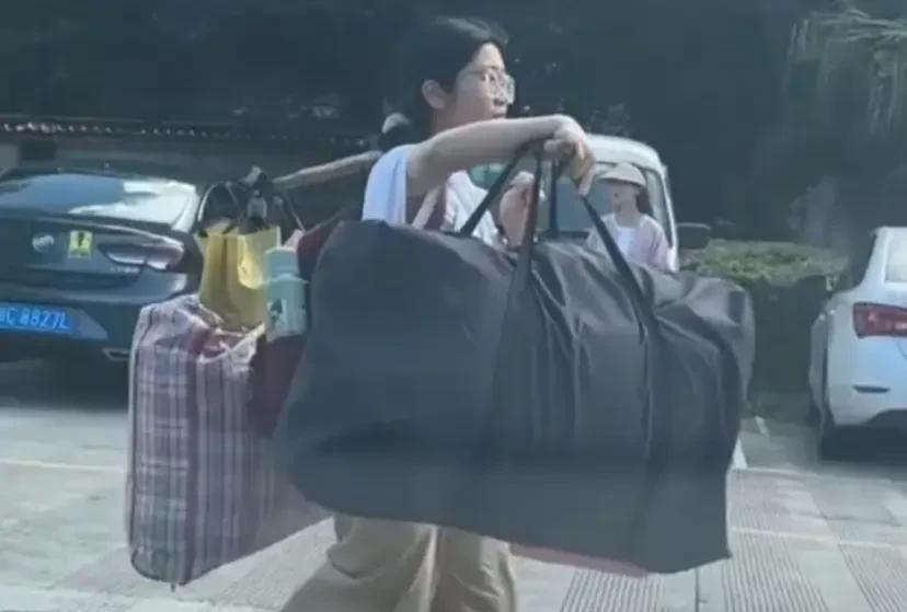 不知大家有没有注意到，广西桂林女孩挑行李的姿势，她将两个大装满物品的塑料袋分别放