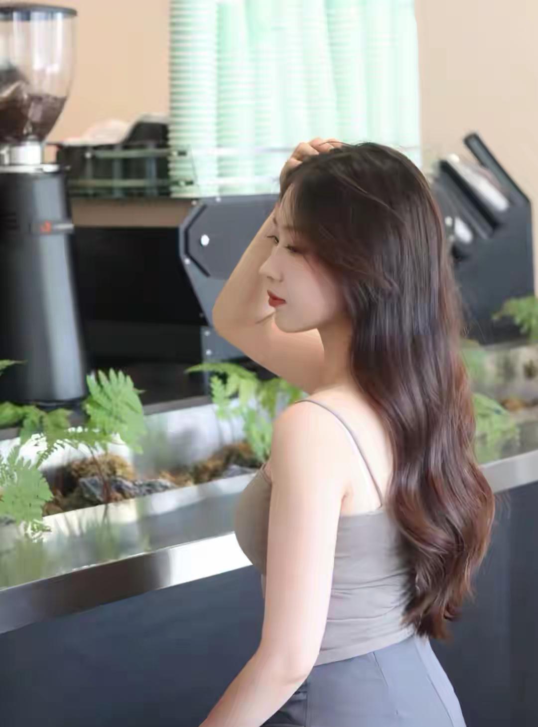 咖啡馆里，优雅女子轻抚秀发，享受宁静时光。