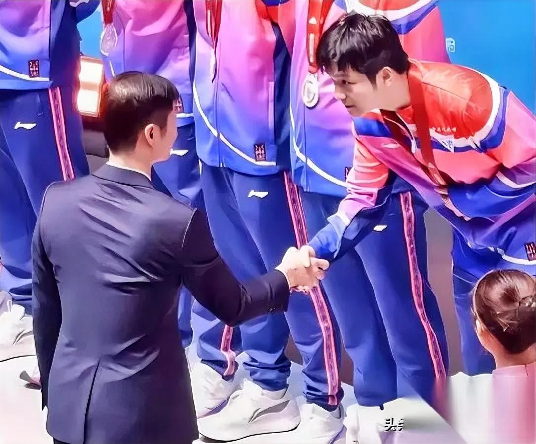 樊振东握手细节亮了！这个动作藏着多少职场情商？王励勤颁奖时，小胖目视对方