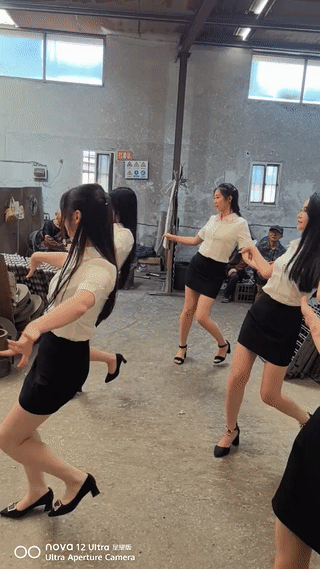 天气闷热，工人干活没精神？工厂老板专门花钱请来美女歌舞团来到工厂车间里。为正