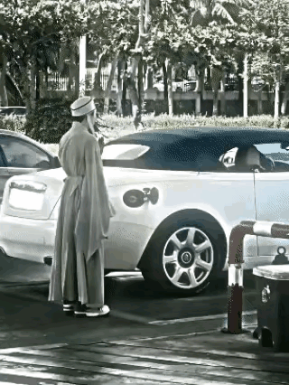 这个男子穿的衣服长袍大袖的，感觉像是模仿古代的风格，可是穿上这样的衣服干些活有时