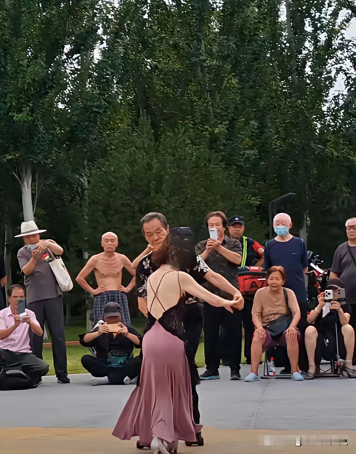 大妈和大爷在广场跳舞，大妈穿着吊带裙子，后背完全露着，周围人看了都说，太漂亮了，