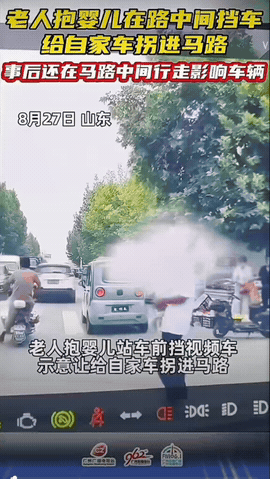 山东，一位老人怀里紧紧抱着年幼的婴儿，直接大步走到机动车道正中间，伸手硬生生拦住
