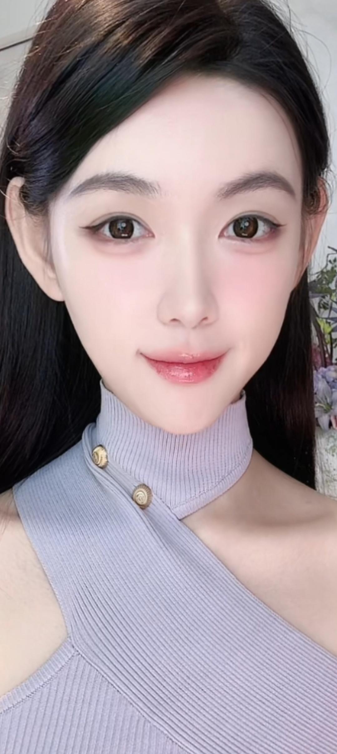 这个女孩穿着紫色高领衫，笑容甜美。