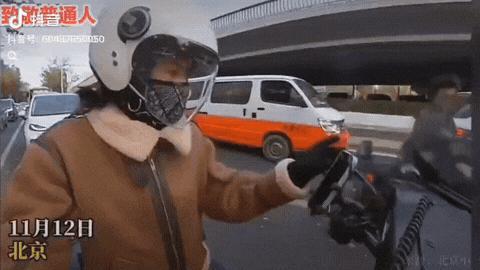 北京，一女子骑着摩托车在等红绿灯时播放音乐，男子突然上前请求女子播放一首《平凡日