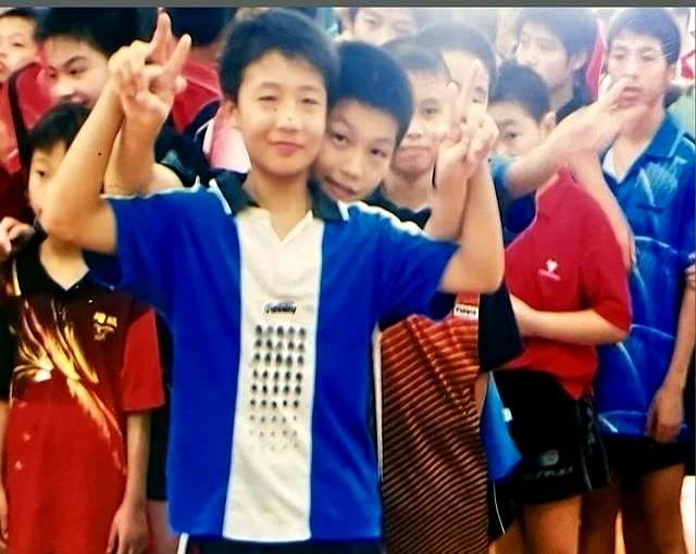 樊振东小时候照片曝光，看着特别乖，还靠着队友拍照。这不光是回忆，更是性格缩影