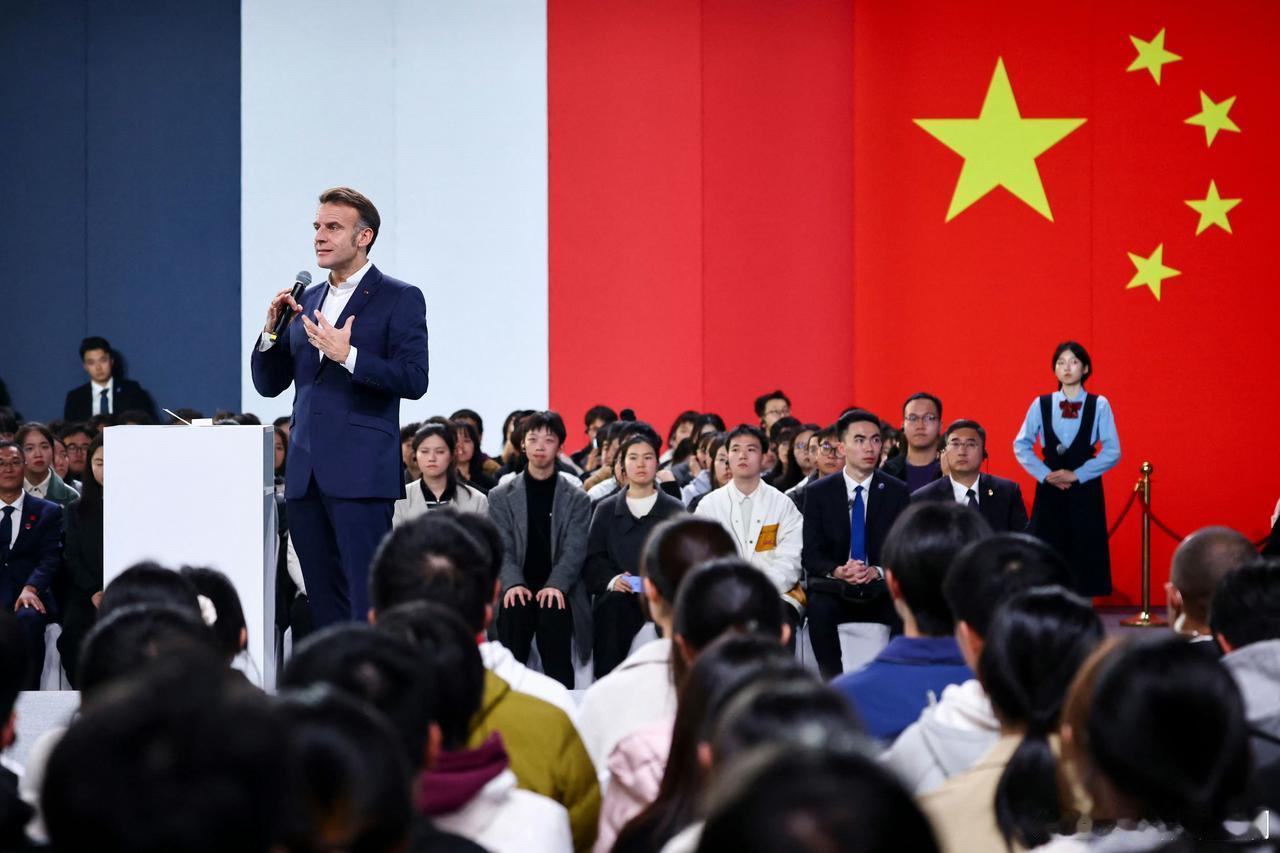 法新社这张图片绝了！可以命名为“国旗下演讲”！这是马克龙在四川大学演讲时，摄影