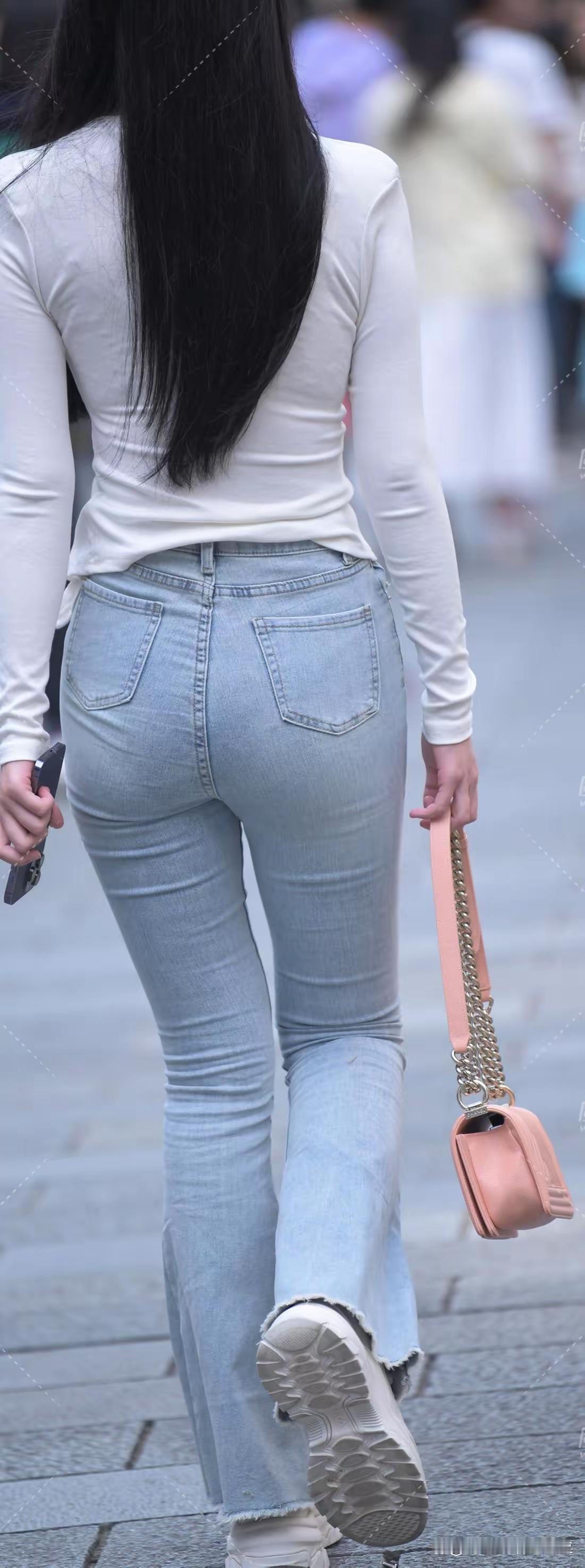 长发妹子穿紧身牛仔裤逛街。