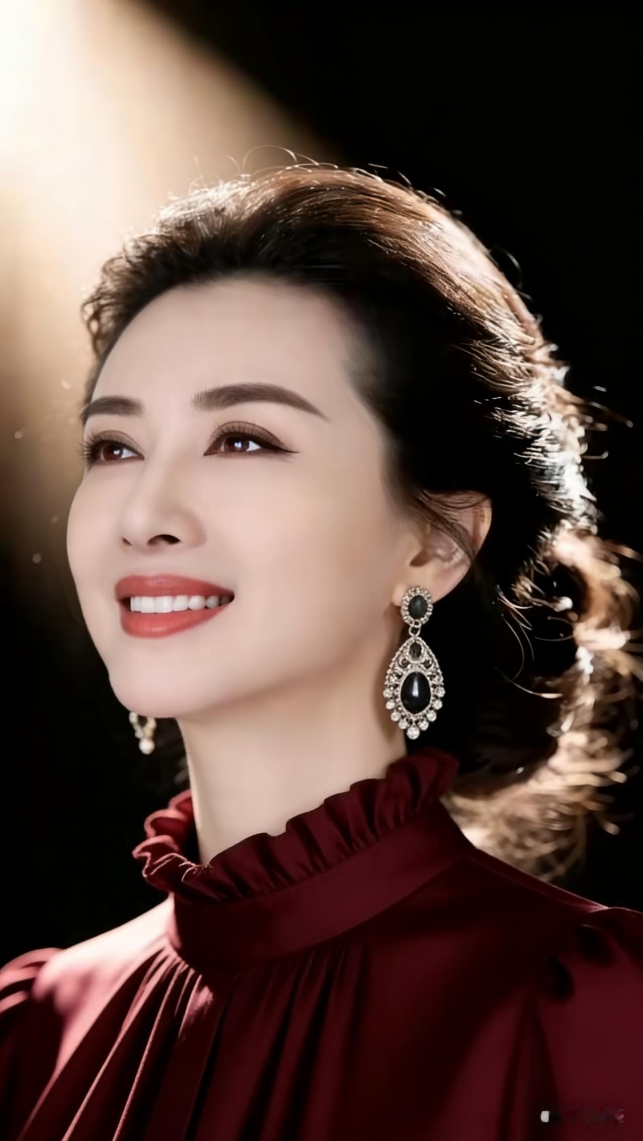 女士佩戴精致耳环，身着浓郁酒红色衣衫，身姿优雅舒展，缓缓抬头望向远方，眉眼温柔自