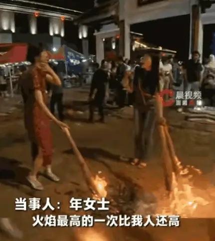 云南的火把节，有一个穿旗袍的女人被很多人围着撒了松香，火苗一下子就蹿了起来，她的