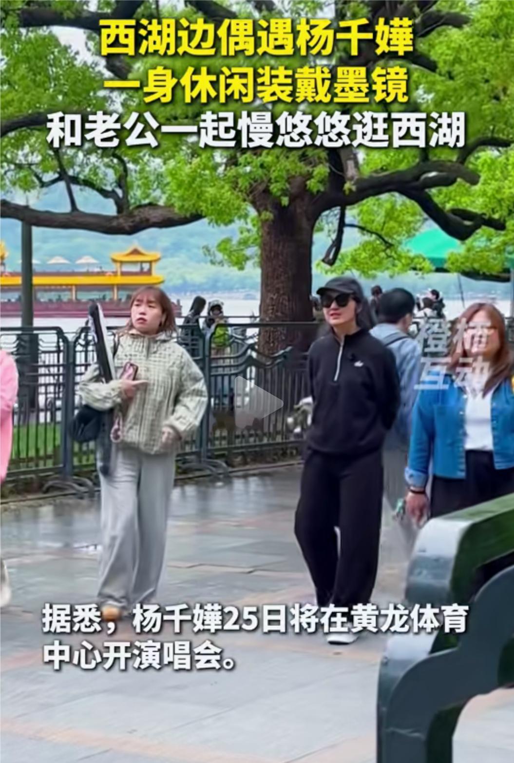杨千嬅和她老公一起游西湖被偶遇，杨千嬅穿着黑色休闲服，戴着墨镜，头戴鸭舌帽，看起