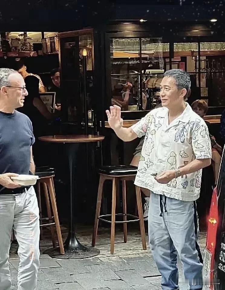 近日，有网友在香港中环偶遇梁朝伟，和外国友人畅聊，一点也不社恐！当天他穿搭随性又
