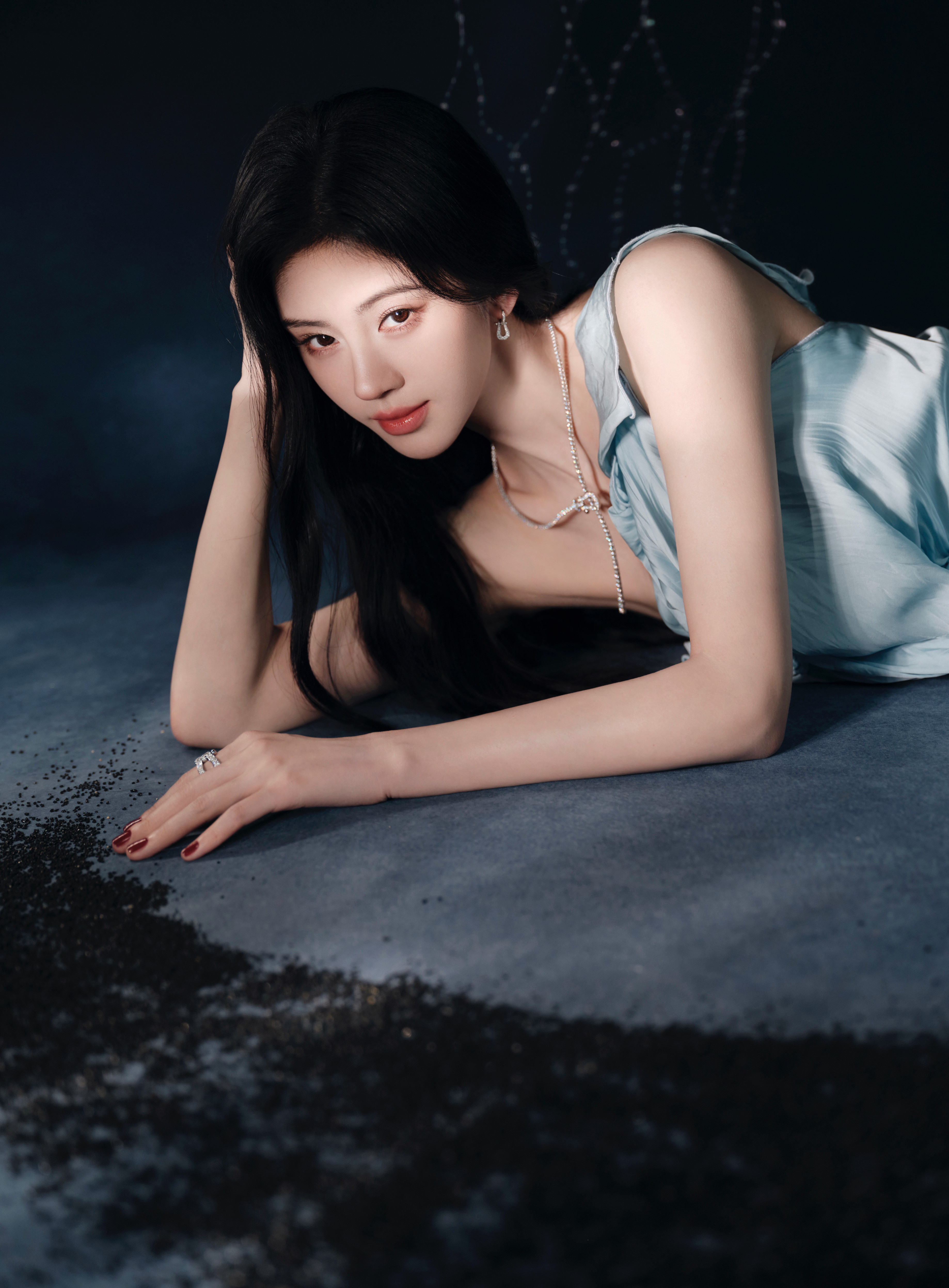 鞠婧祎冷调蓝光揉进浅蓝裙裾，斜肩的褶皱藏着温柔的棱角，聚光灯下的一抹冰蓝，是独