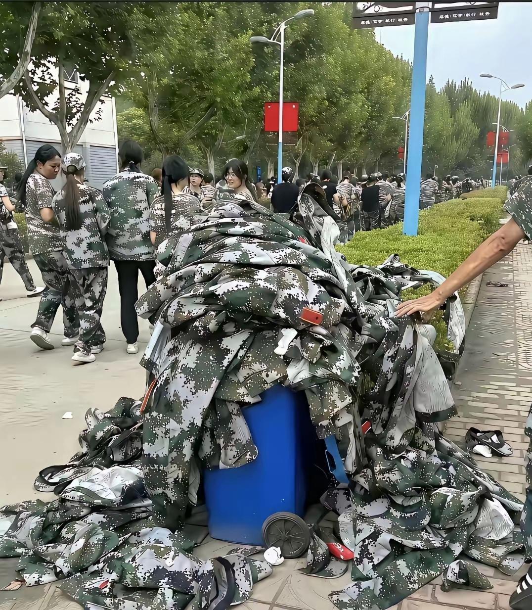开学季，垃圾桶堆满了军训服！军训刚落下帷幕，校园垃圾桶就被崭新的迷彩服堆满，
