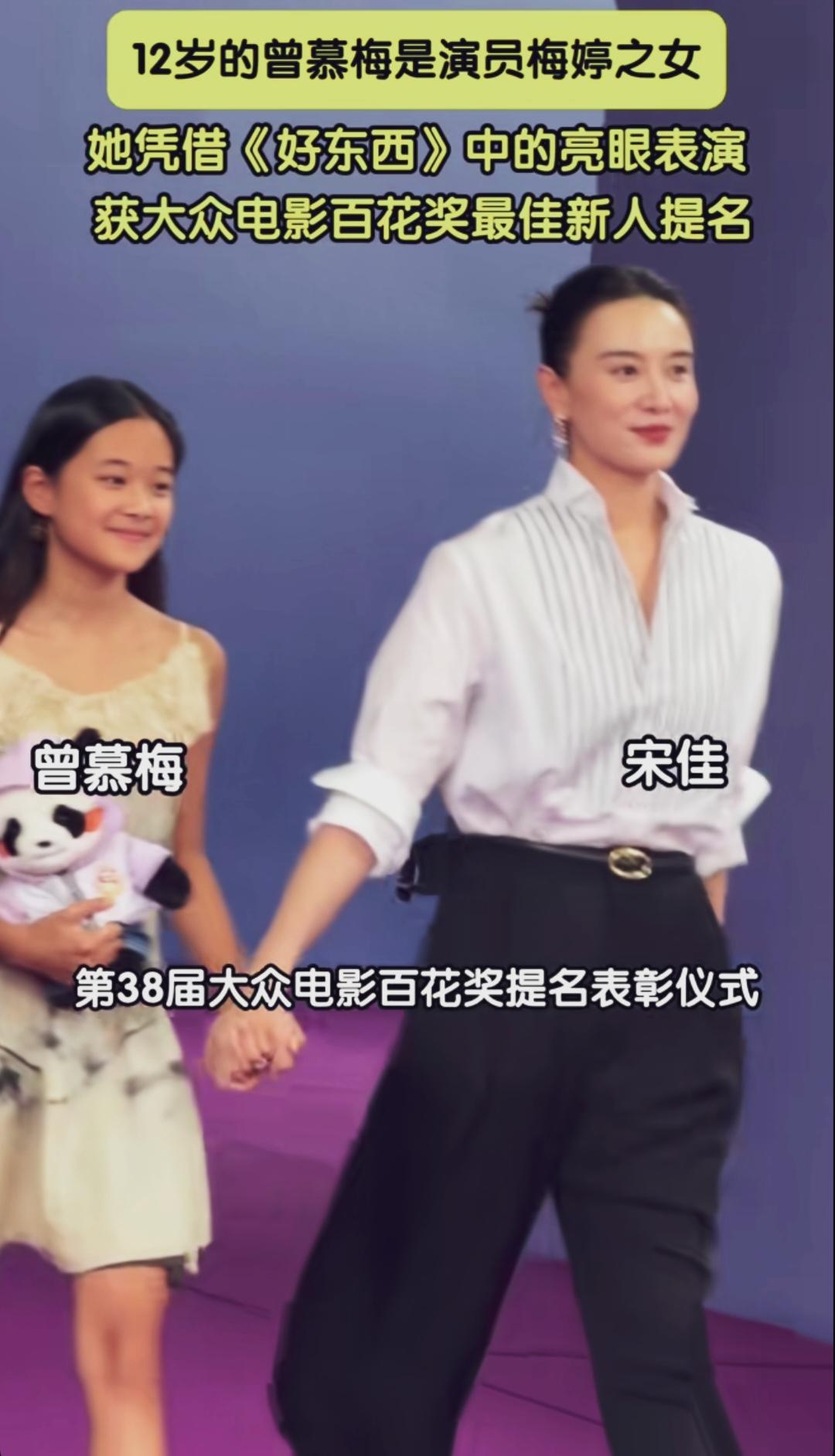 宋佳牵着梅婷女儿曾慕梅走红毯，宋佳白衬衣配黑裤子英姿飒爽。梅婷女儿嘴巴一抿有梅婷