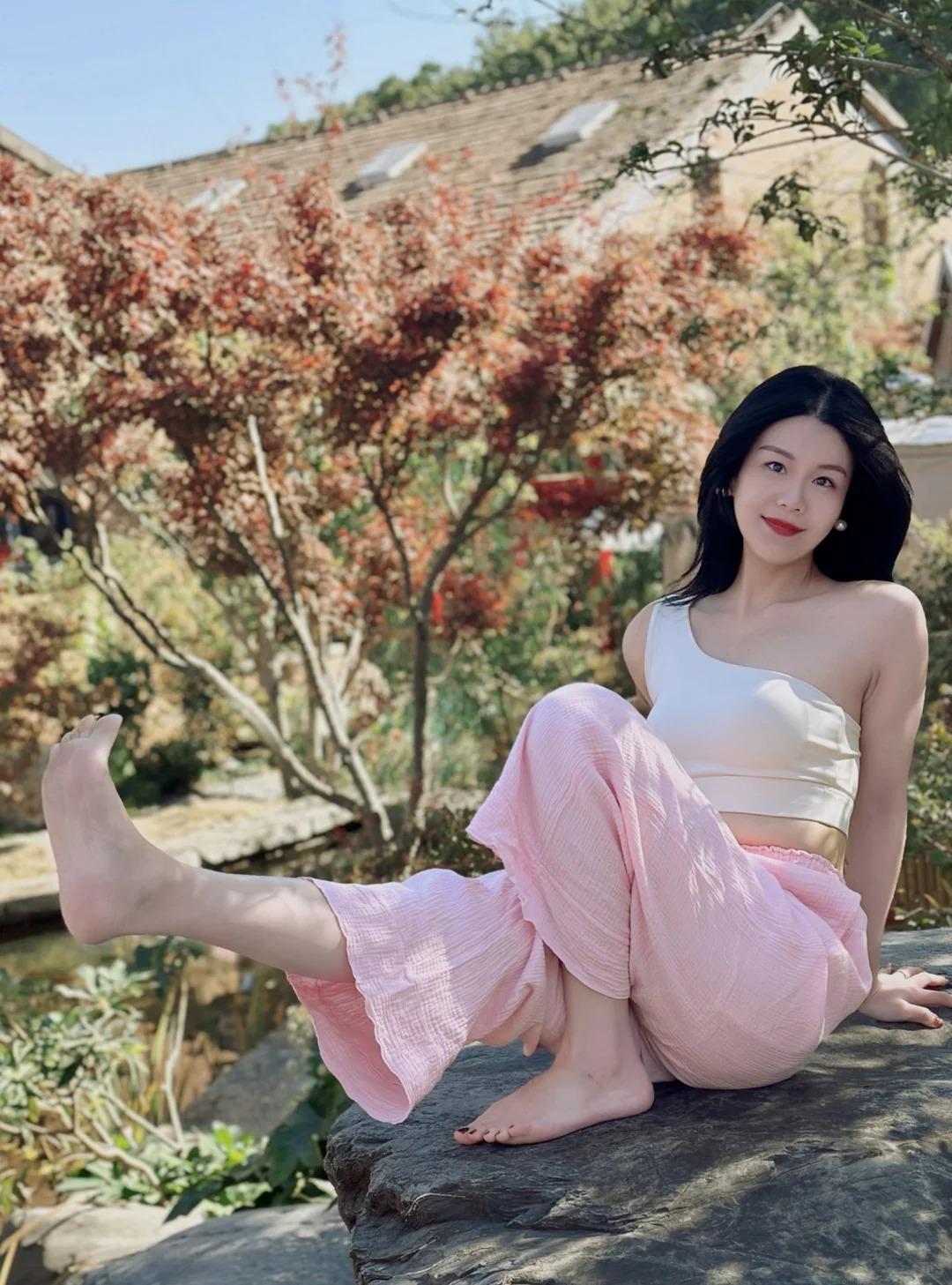 春日花园，赤脚轻触青石，仿佛与大地静静对话。粉色阔腿裤随着微风肆意拂动，每一寸褶