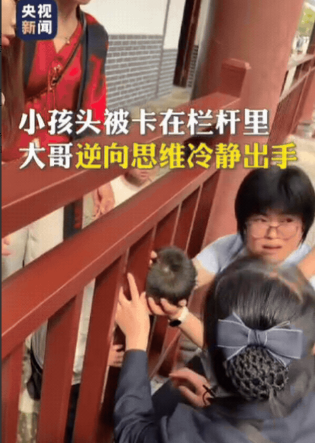 太有头脑了！湖南郴州，小孩游玩时不慎被卡栏杆，大人在后面拉拽，疼得小孩龇牙咧嘴，