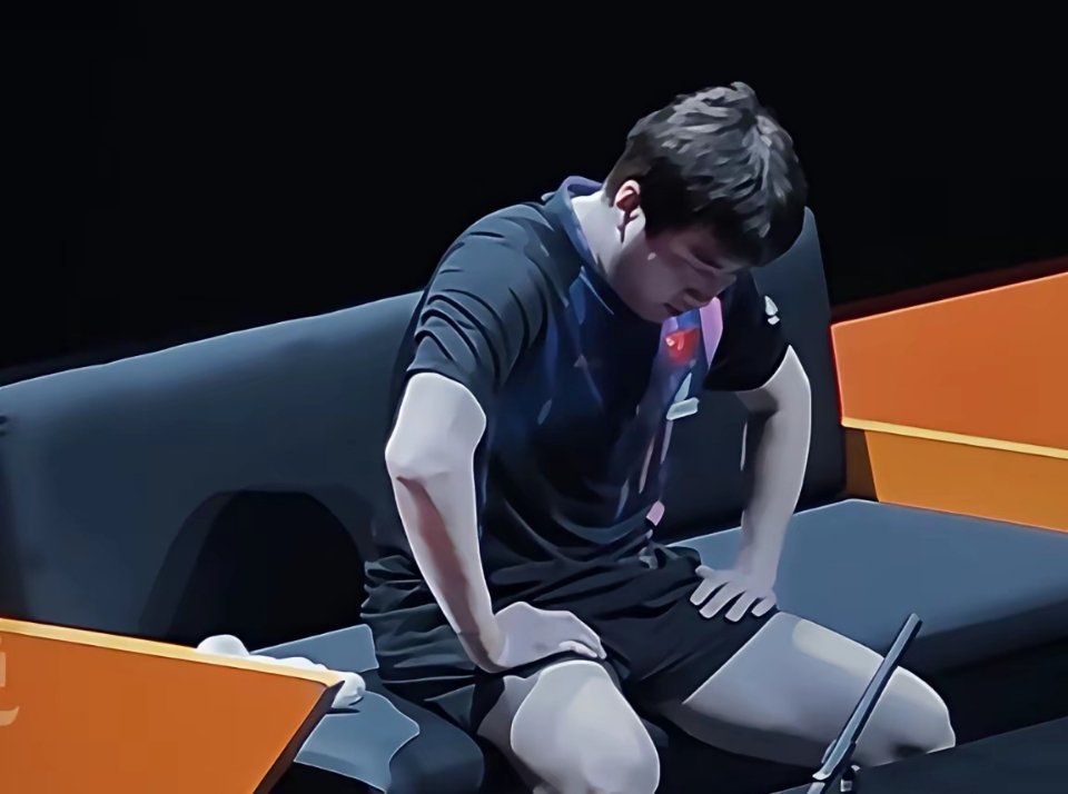 梁靖崑的叹息：一个时代的落幕！30岁的梁靖崑，坐在板凳上，双手撑着大腿，低头看