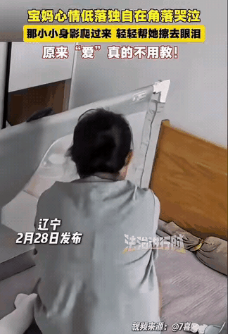泪目了！2月28日，辽宁一宝妈情绪低落，背着宝宝坐在床边默默的流眼泪，刚会爬的宝