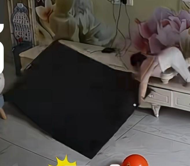 姑姑在客厅独自照看双胞胎侄女，没想到姑姑给妹妹穿袜子时，一个不注意姐姐爬上电视