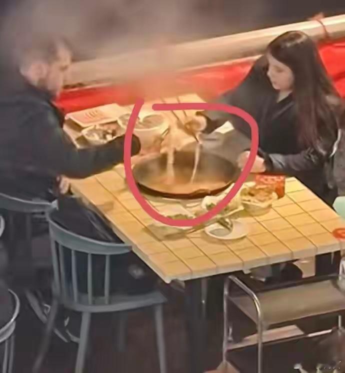 两外国人在重庆用筷子烫火锅镜头里，两人手持筷子的姿势略显笨拙，夹菜时要么夹空滑落