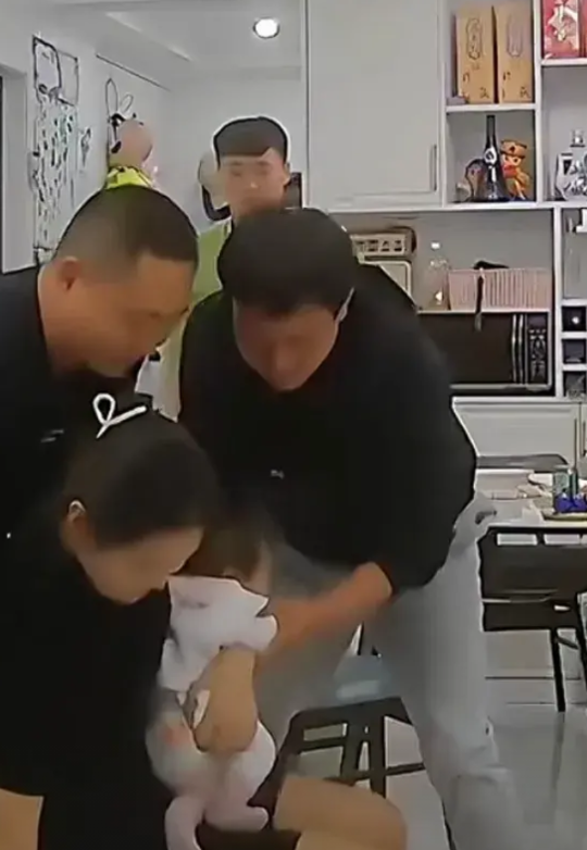 安徽一女子抱着孩子不小心在客厅滑倒，   老公的朋友都在饭桌上要吃饭，见状赶紧