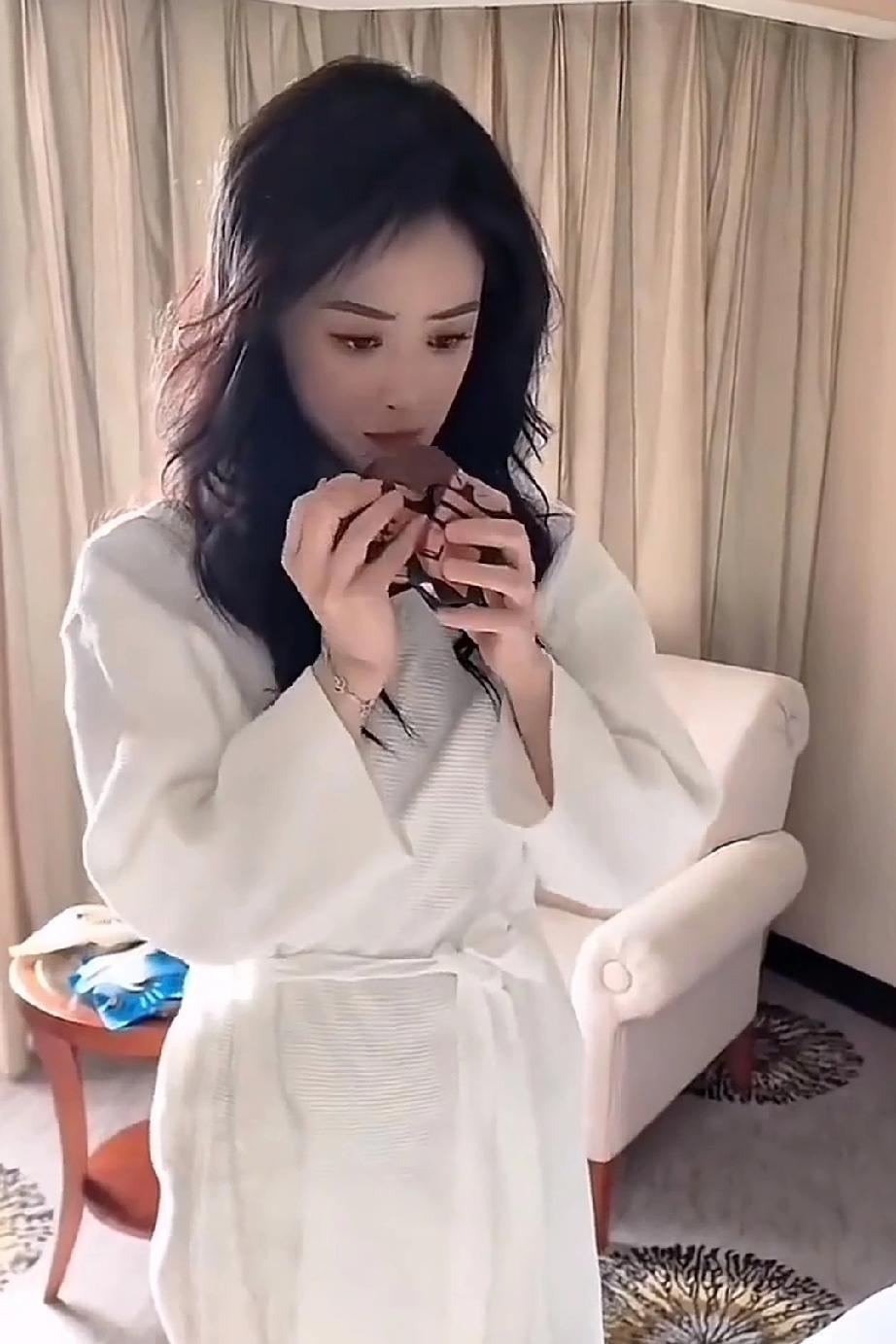 蒋欣就像一个爱偷吃的小孩，拿起一块蛋糕正准备往嘴里塞，被助理发现了说:“你又在偷